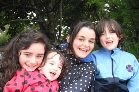 Emily as a child cuddling her three siblings