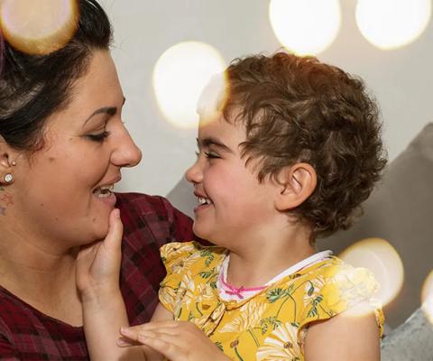 An adult and child  looking at each other surrounded by lights