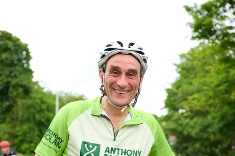 A man posing in his Anthony Nolan RideLondon race shirt while sitting on his bike