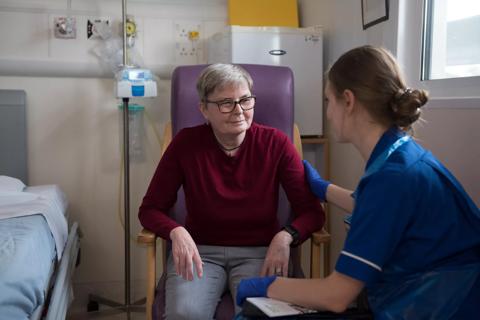 Female patient in hospital ward with female nurse