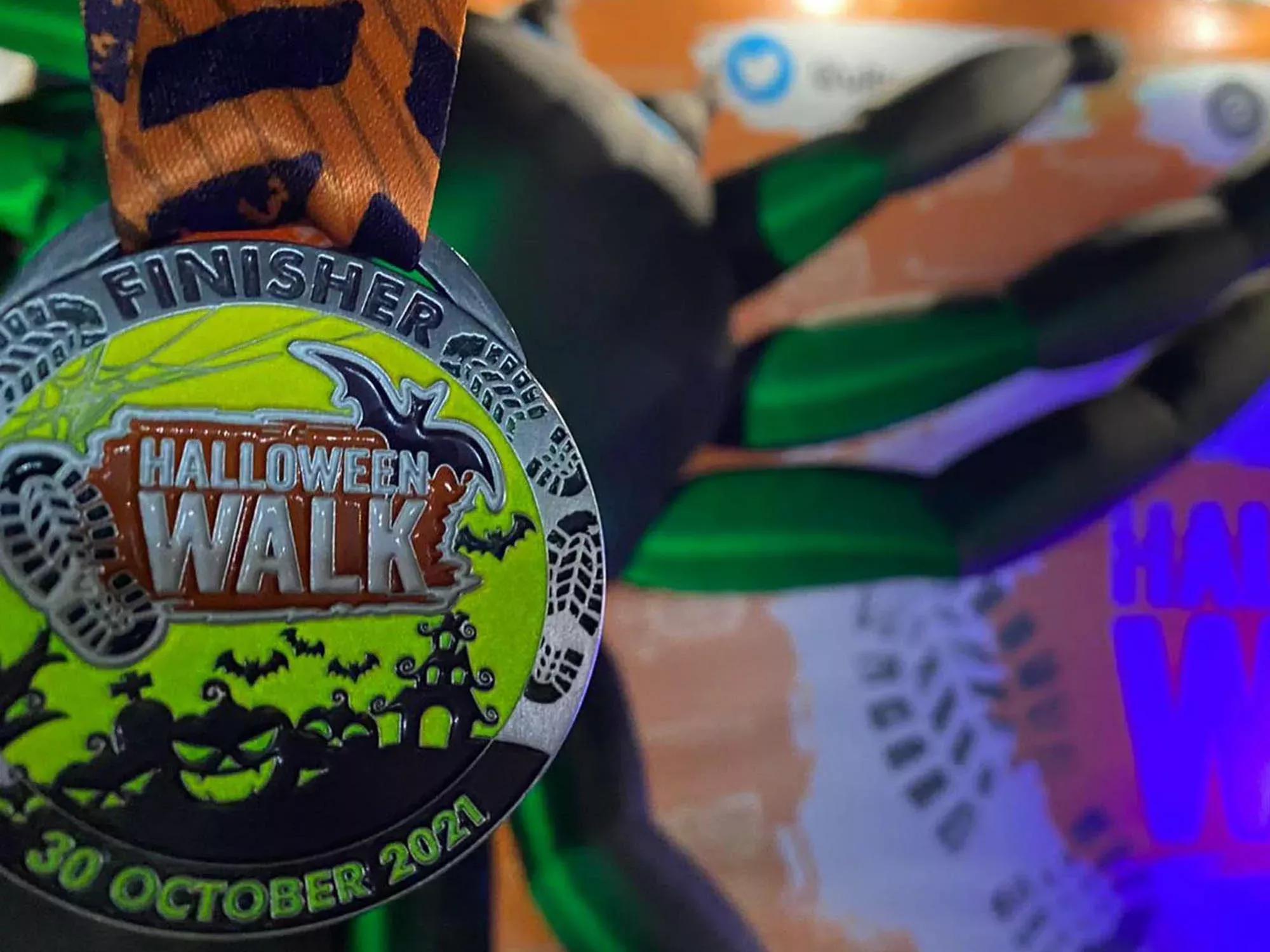 Photo of a medal which says 'Halloween Walk' on the front