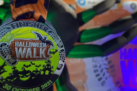 Photo of a medal which says 'Halloween Walk' on the front