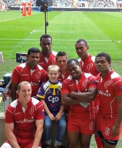 Alex in the middle of the rugby team all smiling at the camera