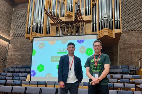 Two people standing in front of an organ