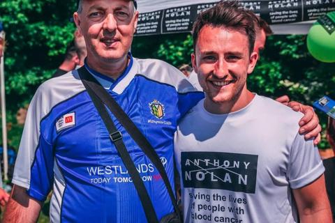 an older man and younger man with arms around each other, one is wearing an Anthony Nolan t-shirt