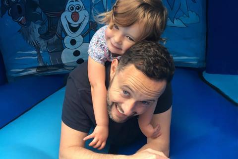 Alex, laughing with his daughter