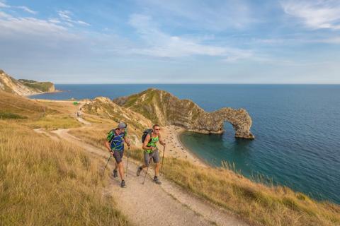 Photo of the Jurassic Coast and a pair of people walking 