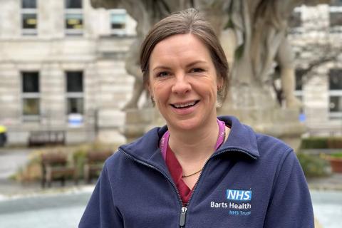 Female healthcare professional standing outside in NHS branded fleece