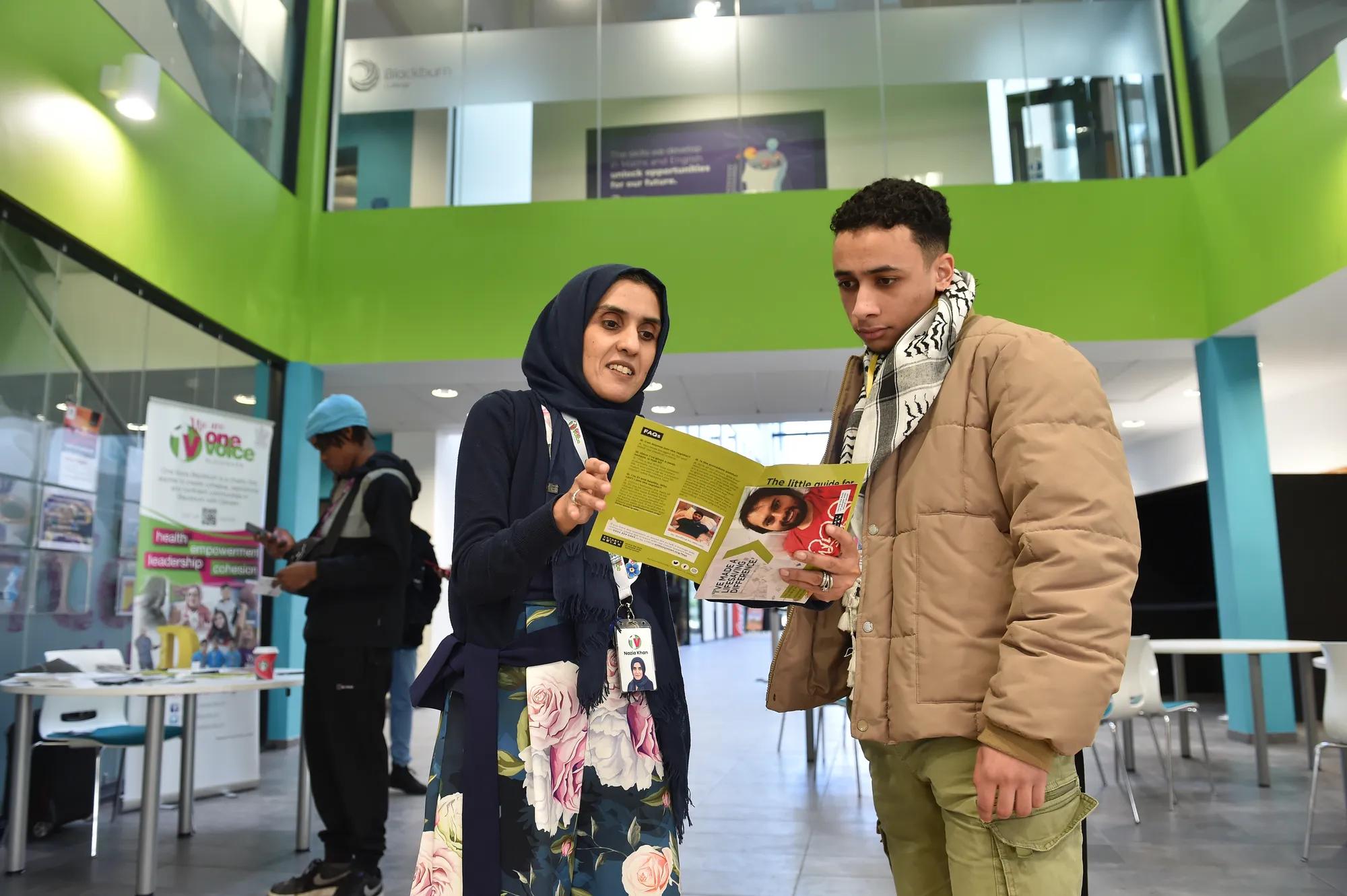 A photograph of a man and woman discussing an Anthony Nolan leaflet