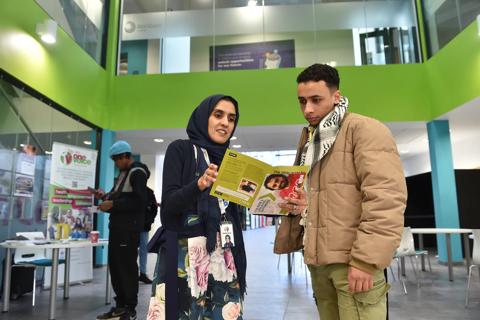 A photograph of a man and woman discussing an Anthony Nolan leaflet