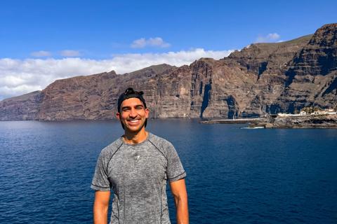Kash, a man in a grey tshirt and black shorts standing in front of a lake