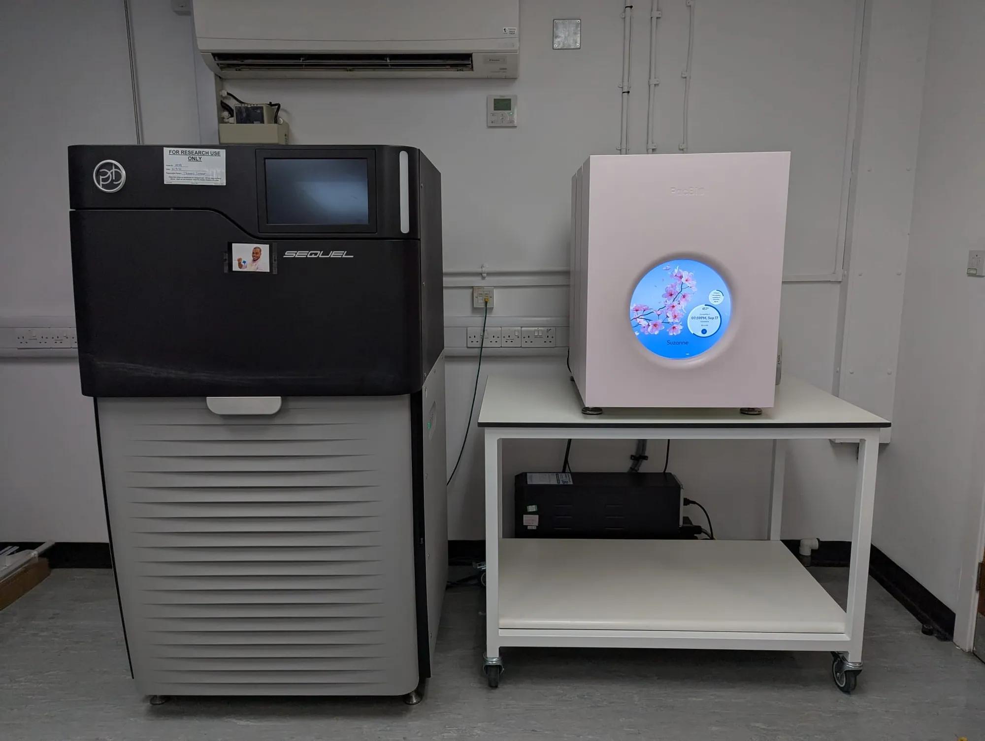 Two genetic sequencer machines next to each other, one significantly smaller and more sleek than the other