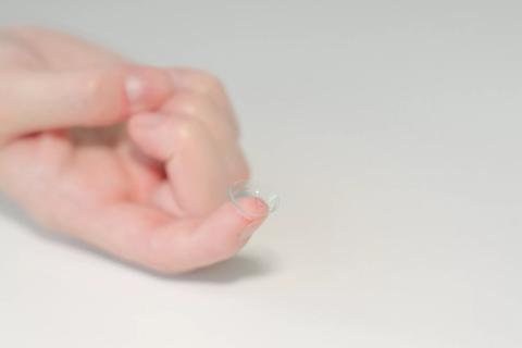 Image of hand holding contact lens