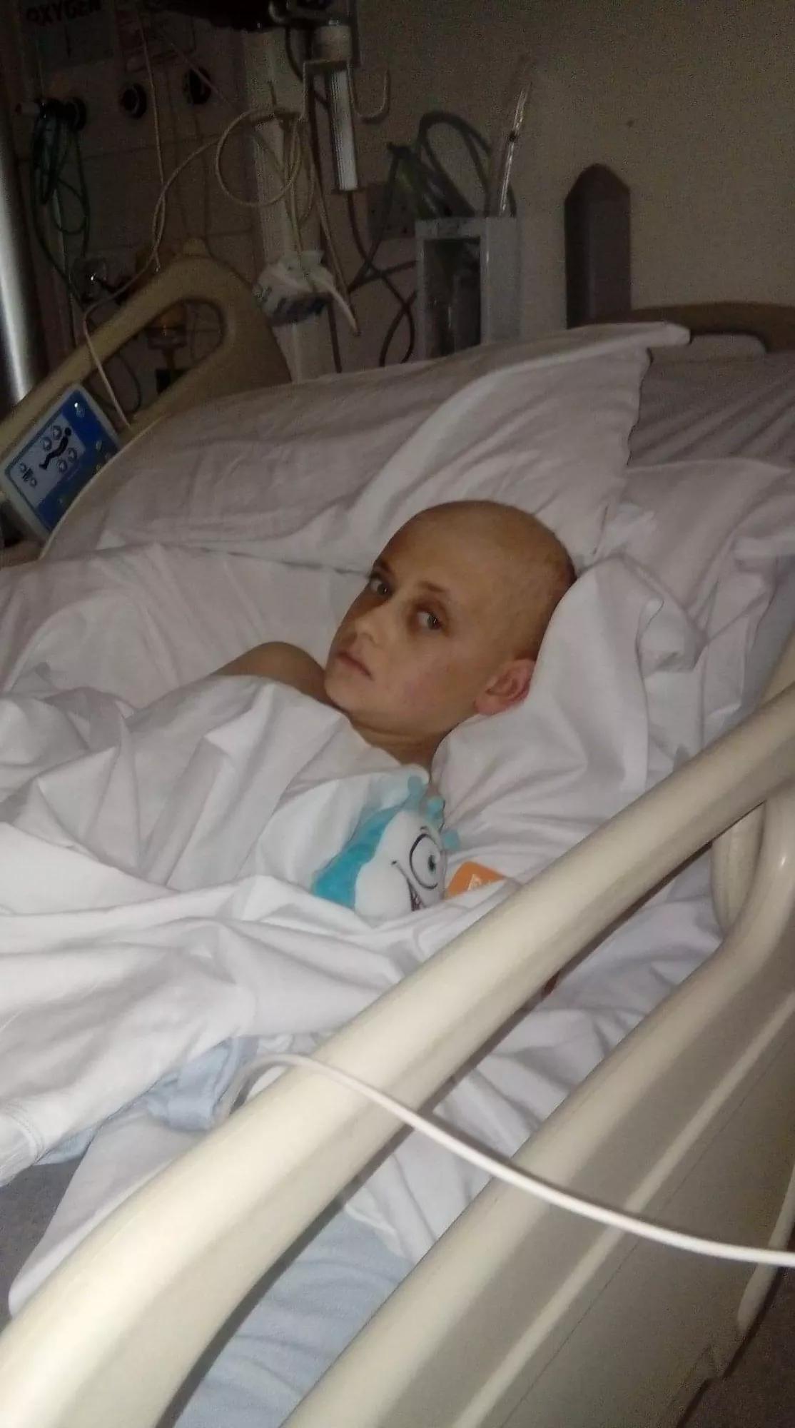 a young boy with no hair in a hospital bed