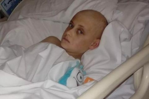 a young boy with no hair in a hospital bed