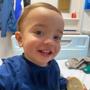 A little boy, Elijah Jones, smiling while sat in a hospital bed