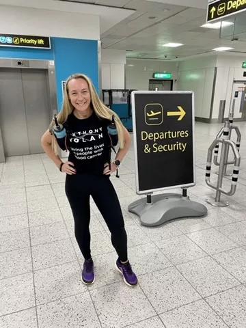 a women smiling in an Anthony Nolan t-shirt at an airport