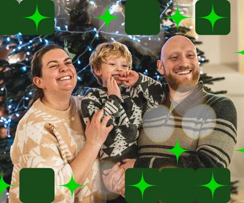 Miles and his parents standing in front of a Christmas tree