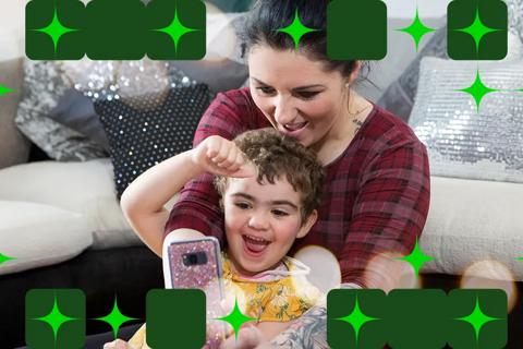 Ava and her mum smiling and looking at a mobile phone