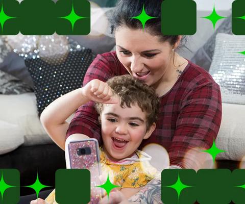 Ava and her mum smiling and looking at a mobile phone