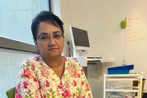 A woman sits in a hospital room