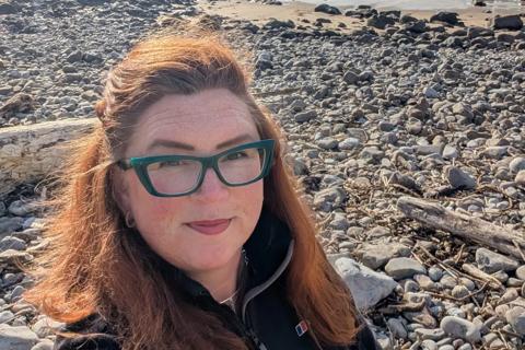 Sian taking a selfie on a stoney beach