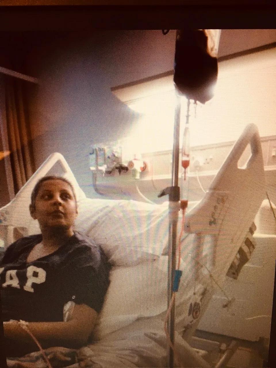 Rita is in a hospital bed looking up at a bag of stem cells