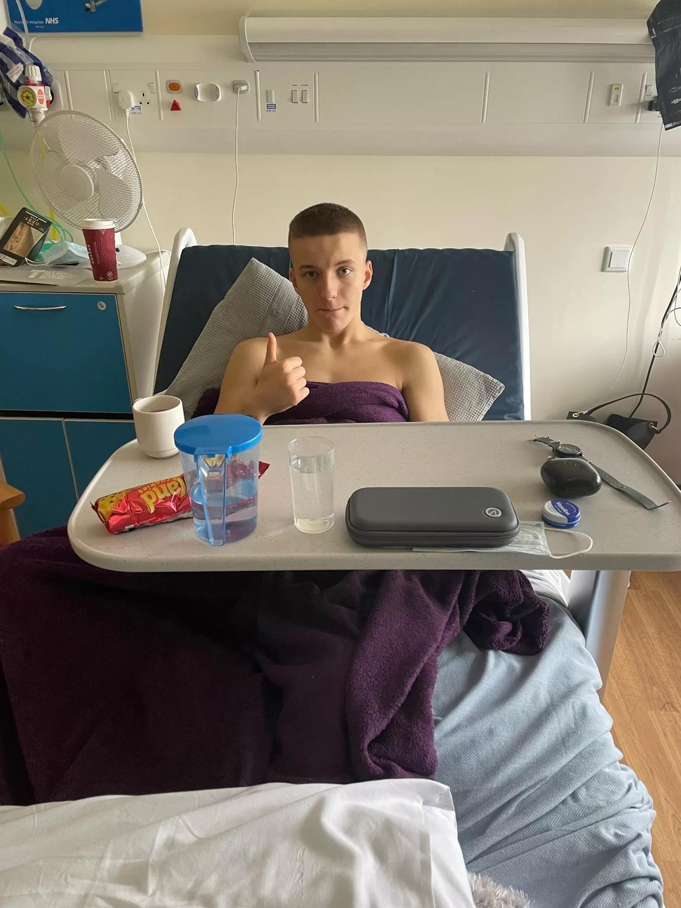 Charlie in a hospital bed giving a thumbs up