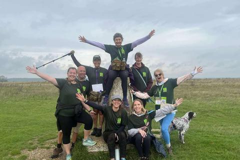 a group of people with their arms outstretched on top of a  hill