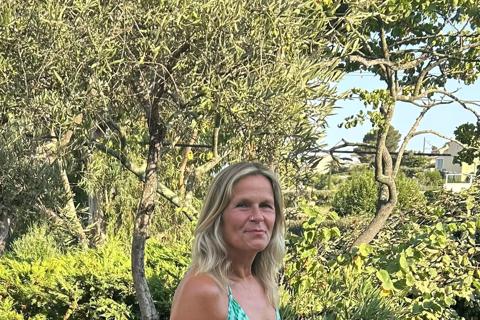 Karen smiling at the camera in front of trees