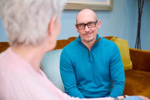 Patient having a conversation with  another on a sofa