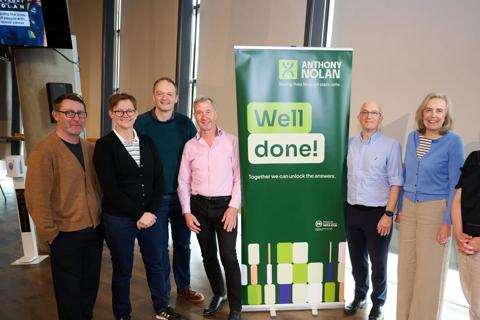 6 members of Anthony Nolan's Strategic Leadership Team stood next to an Anthony Nolan branded banner which reads 'Well done!'