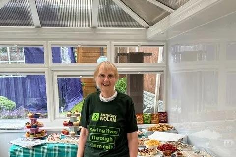 Helen's standing in front of a buffet lunch wearing an Anthony Nolan tshirt