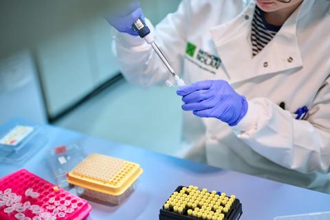 Researcher using a micropipette in a tube