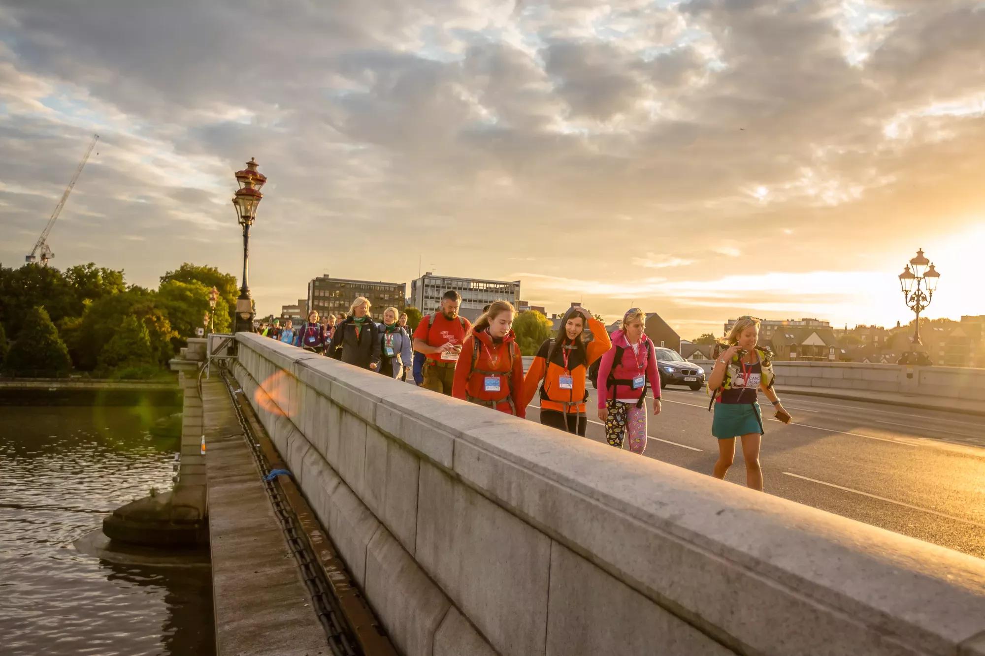 Photo of a group of people walking over the Thames Bridge