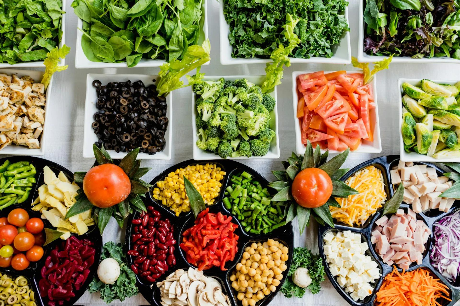 An assortment of fresh chopped vegetables, beans and grains in colourful patterns