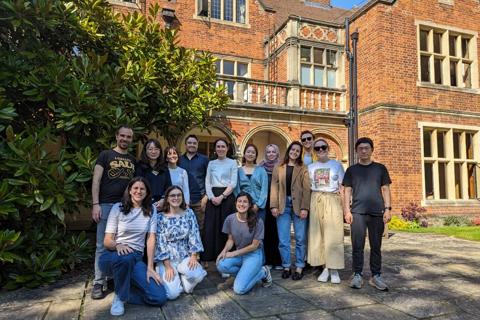 A group of young people standing in front of a building on the lab retreat