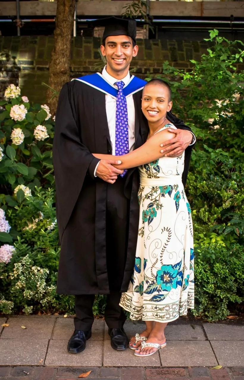 Kash in his graduation gown being hugged by Rita 