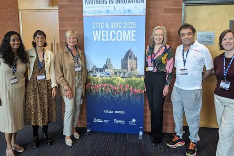 Several people standing in front of an IDRC banner