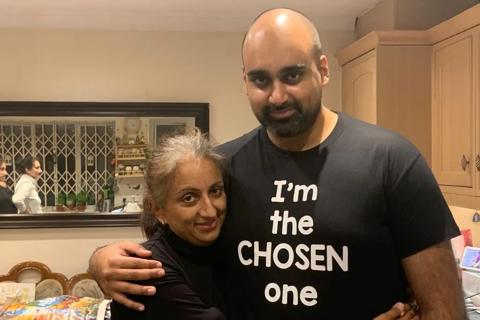 A South Asian woman with a taller South Asian man, they have their arms around each other