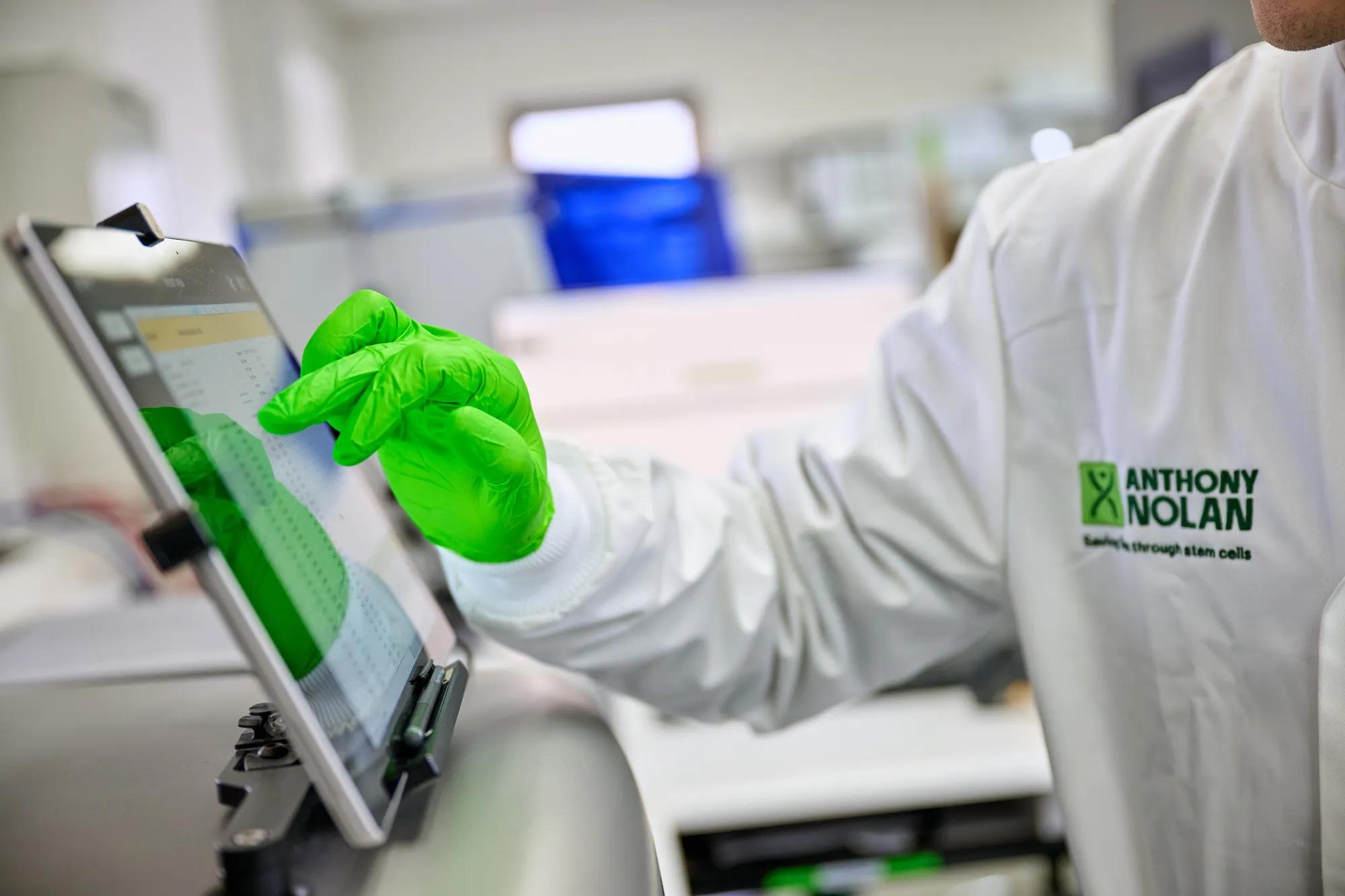 A researcher using a display screen on a DNA extraction machine