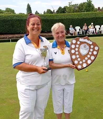 two women on a bowling green, one is holiday a winners plaque 