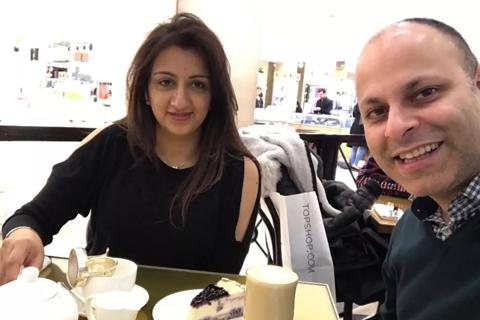 Kal, a South Asian woman with a man at a table with tea and cake