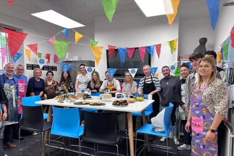 A group of staff from IGNIFI around a table of baked goods looking at the camera