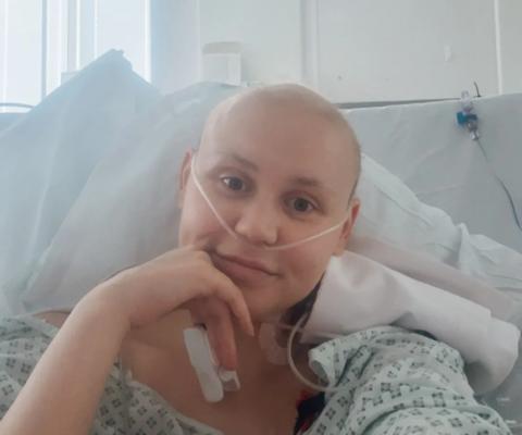 Faith in hospital bed smiling at camera