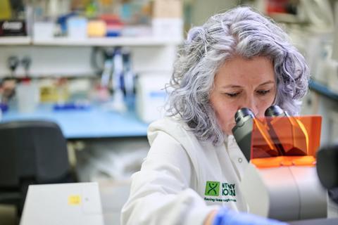 A researcher examining a sample under a microscope