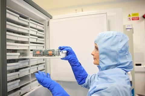 Researcher examining a sample in a cryogenic refrigerator