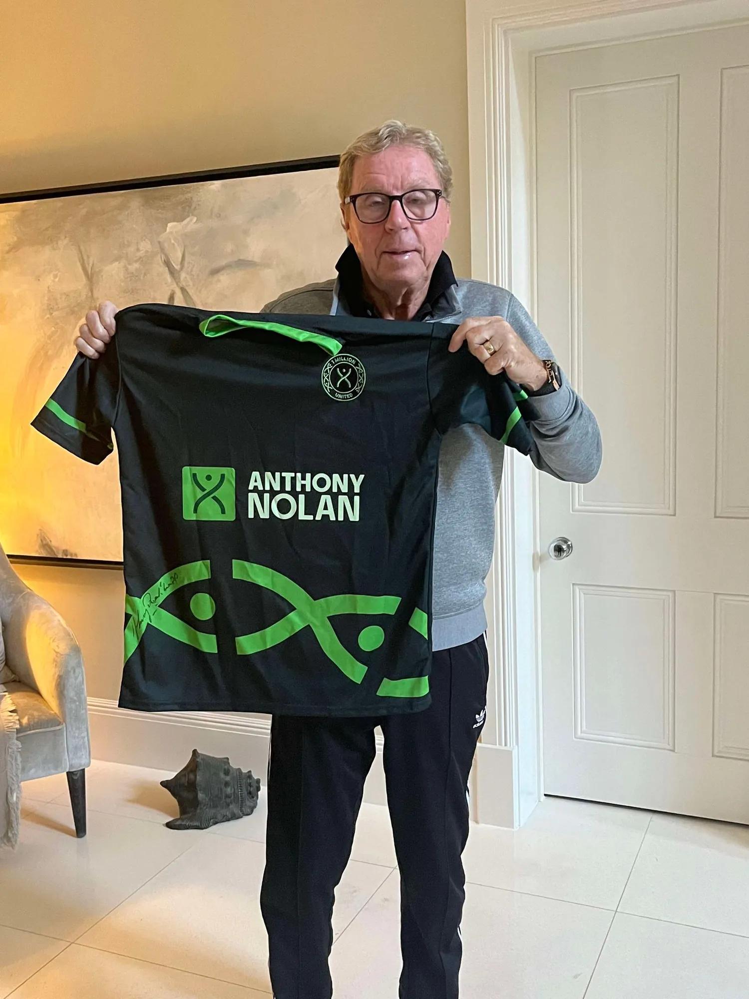 Harry Redknapp holding a green football shirt up