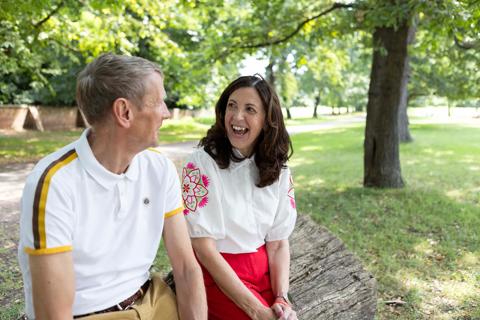 White man and woman smiling and happy together sat outside