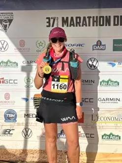 a woman holding up her medal